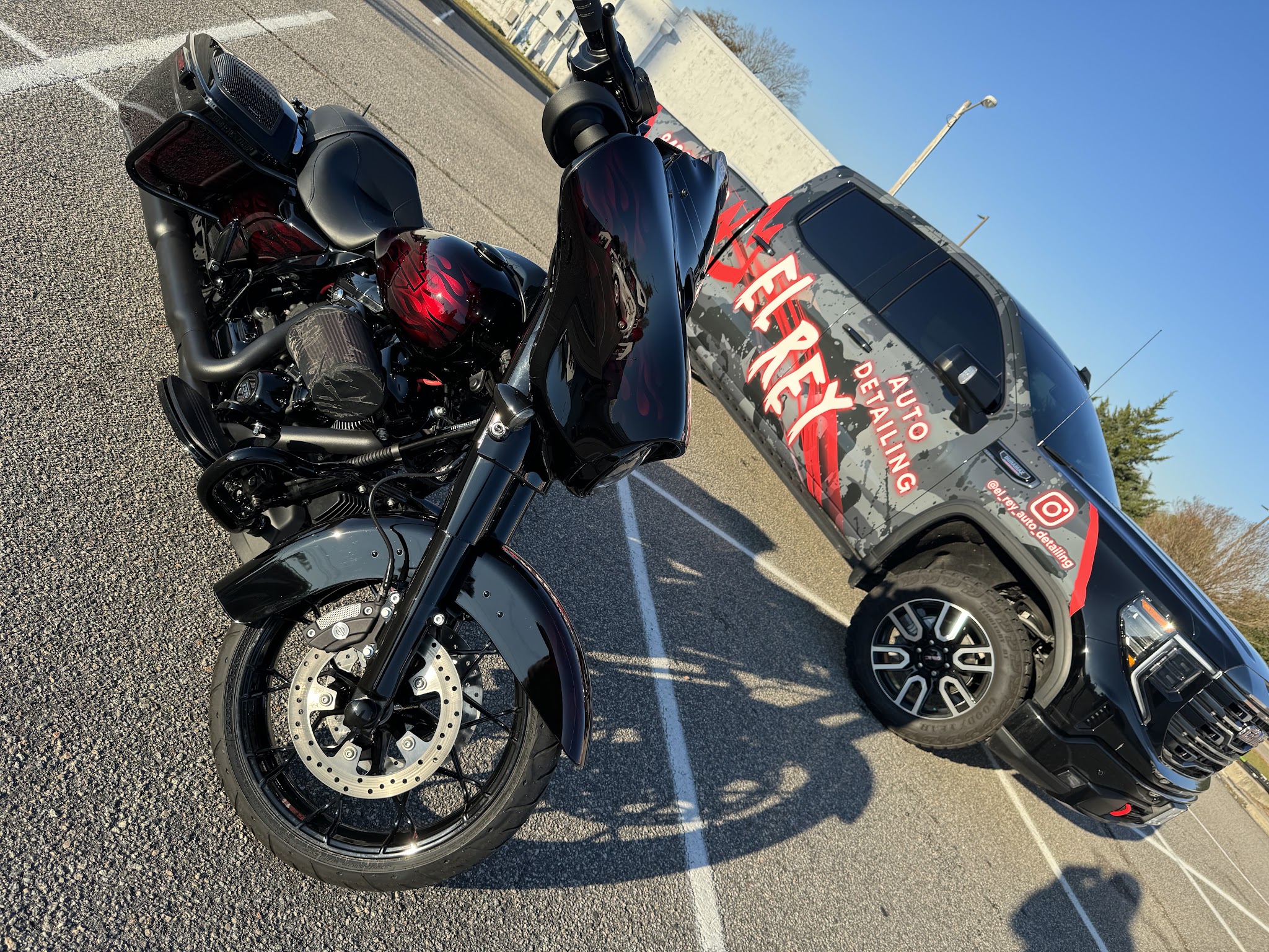A black cruiser motorcycle parked beside the El Rey wrapped truck